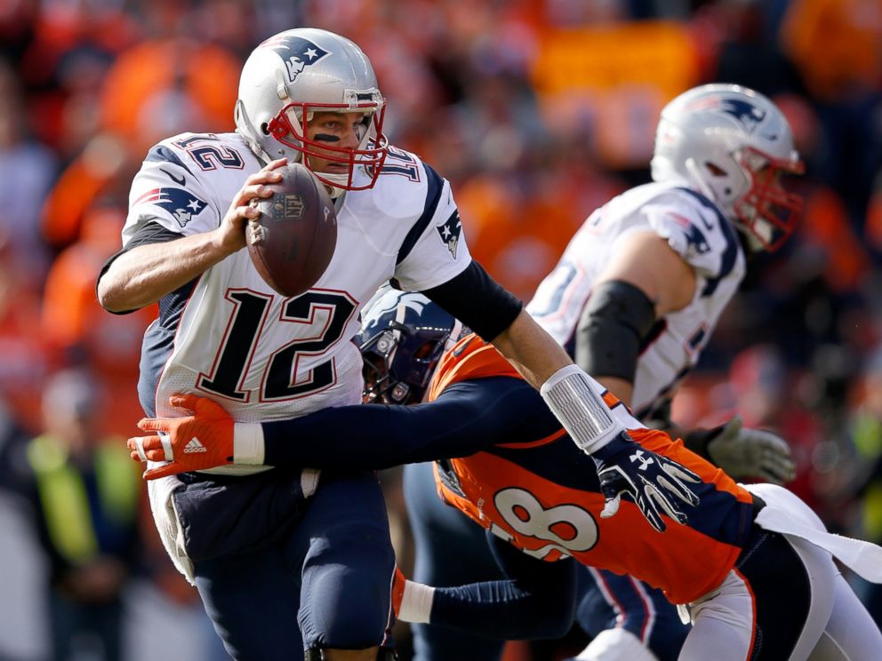 PHOTO: Tom Brady of the New England Patriots tries to evade a tackle by Von Miller of the Denver Broncos in the first half in the AFC Championship game at Sports Authority Field at Mile High on Jan. 24, 2016 in Denver, Colo.