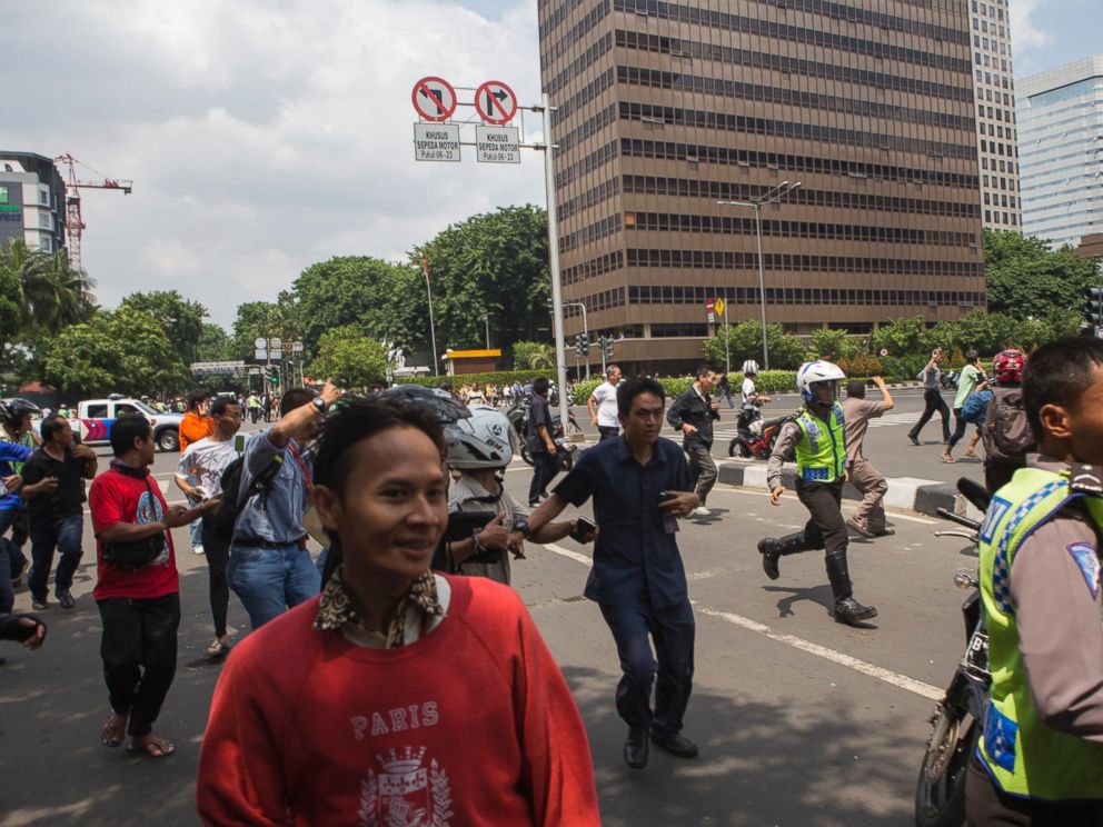 PHOTO: Office workers and unarmed police officers flee from the scene after a gun-battle broke out at the scene of an attack in Jakarta, Indonesia, Jan. 14, 2016.