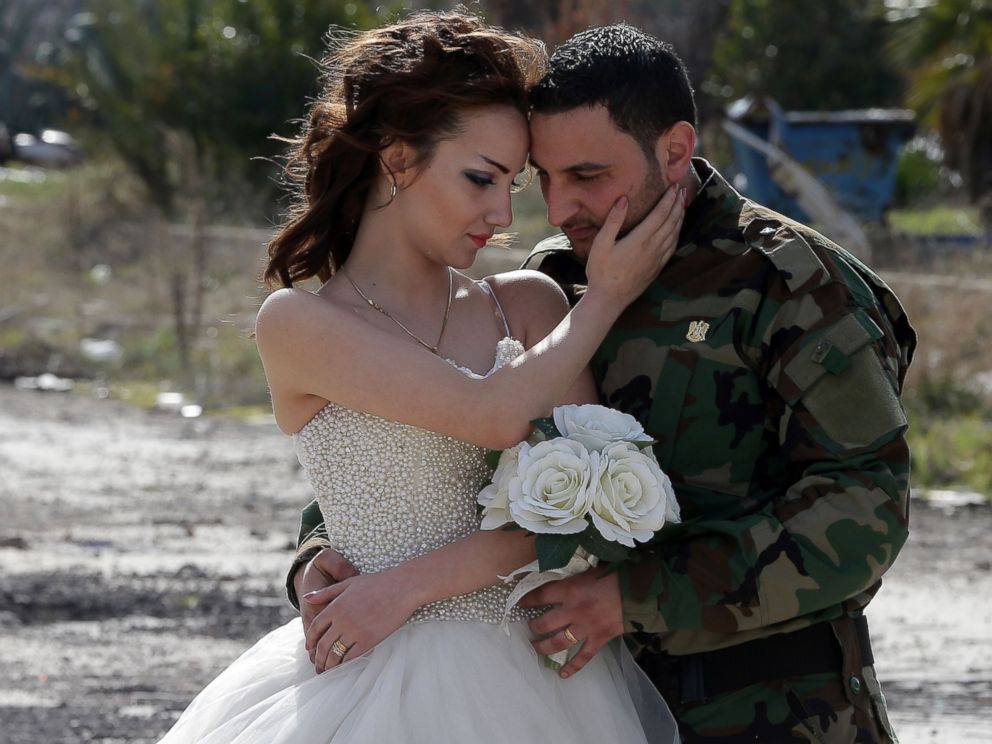 Newly-wed Syrian couple Nada Merhi, and Syrian army soldier Hassan Youssef, pose for a wedding picture amid heavily damaged buildings in the war ravaged city of Homs on Feb. 5, 2016.