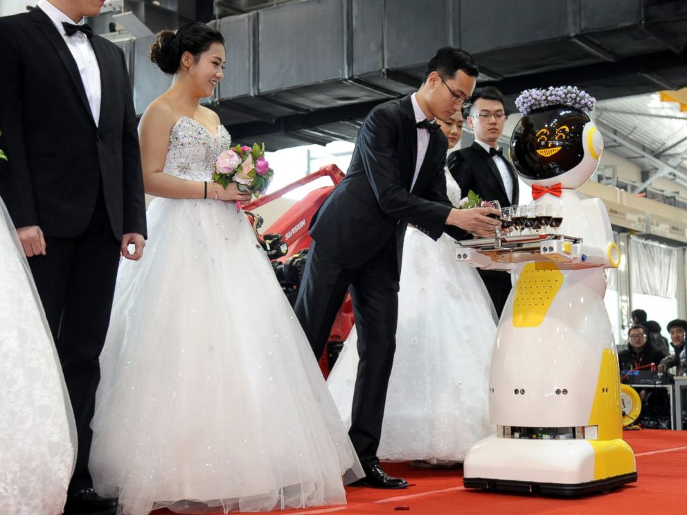 PHOTO: A service robot hands out glasses of red wine for brides and grooms during a group wedding ceremony at a robots factory, Jan. 20, 2016, in Shenyang, China.
