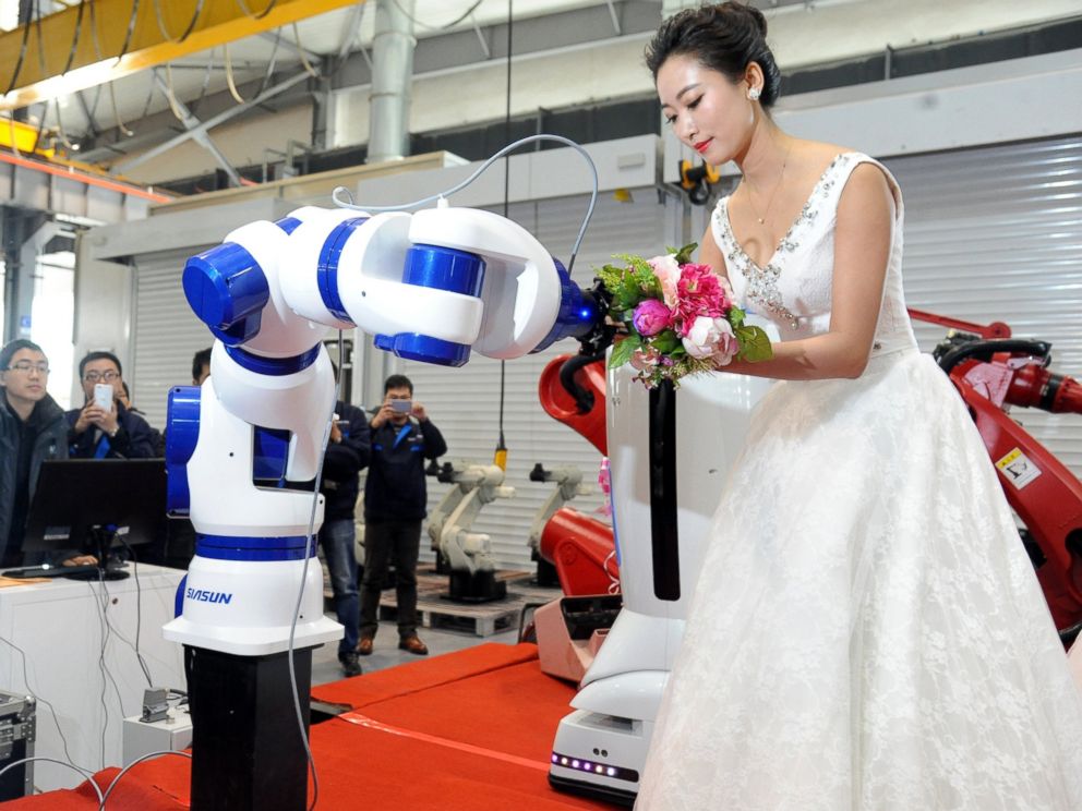 PHOTO: A bride gives the bouquet to a robot during a group wedding ceremony at a robot factory, Jan. 20, 2016, in Shenyang, China.