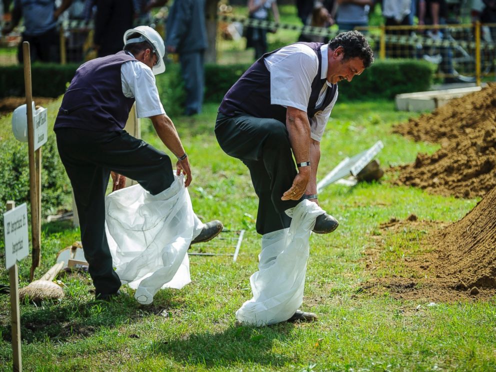 PHOTO: Gravediggers take off their disposable overalls during the first National Grave Digging competition at the public cemetery of Debrecen, Hungary, June 3, 2016.