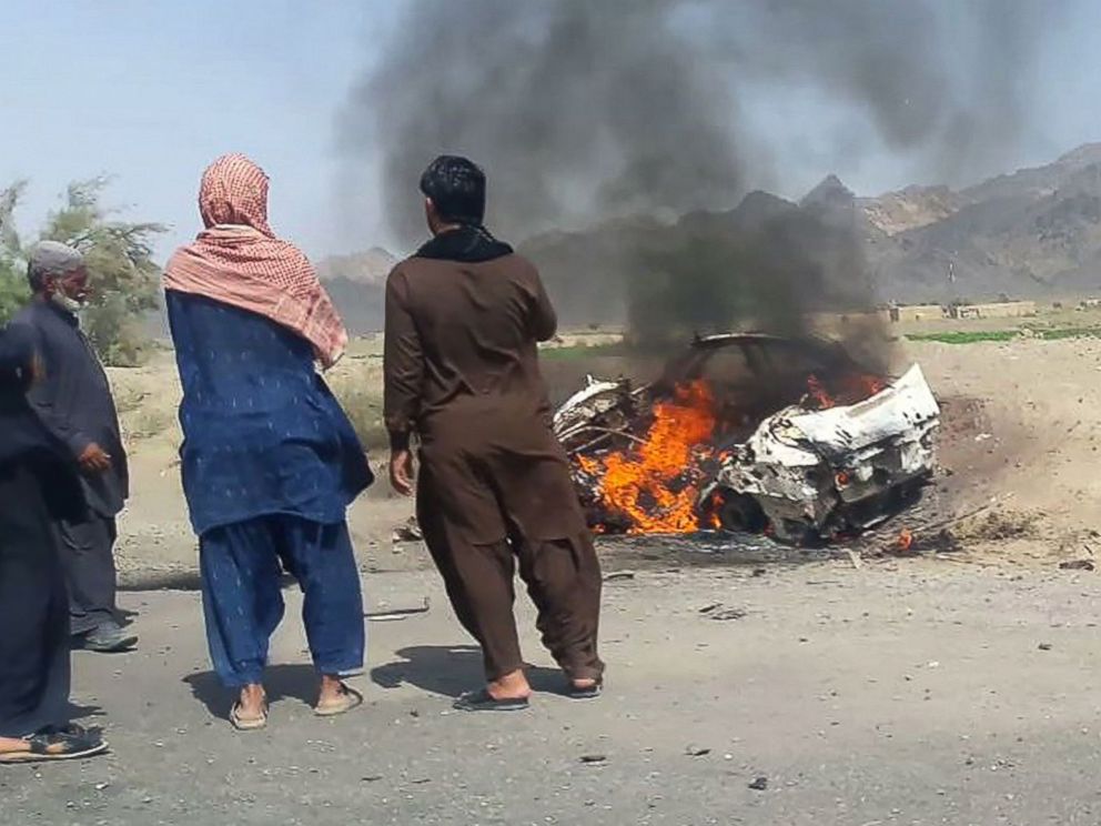 PHOTO: This photograph taken, May 21, 2016, shows Pakistani residents gathering around a destroyed vehicle hit by a drone strike in which Afghan Taliban Chief Mullah Akhtar Mansour was believed to be travelling.