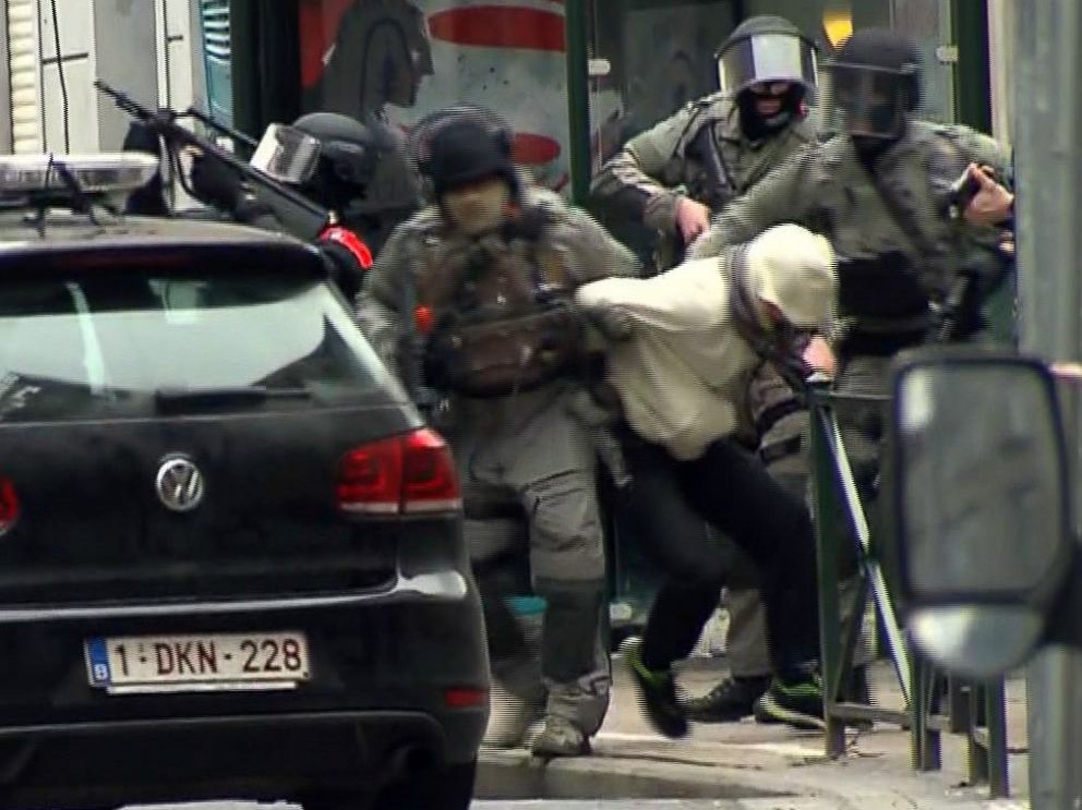 PHOTO: Armed police officers carry a suspect to a police vehicle during a raid in the Molenbeek neighborhood of Brussels, Belgium, March 18, 2016.