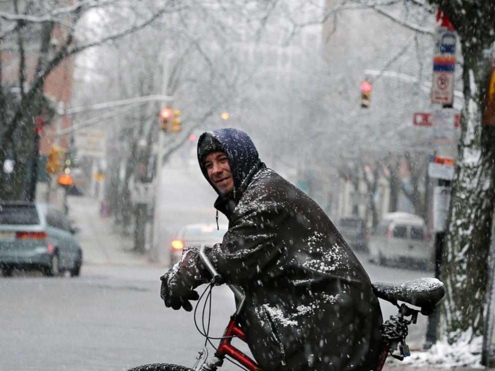PHOTO: Rob Bitz rests on his bicycle in the snow along a street on Jan. 17, 2016, in Trenton, N.J.