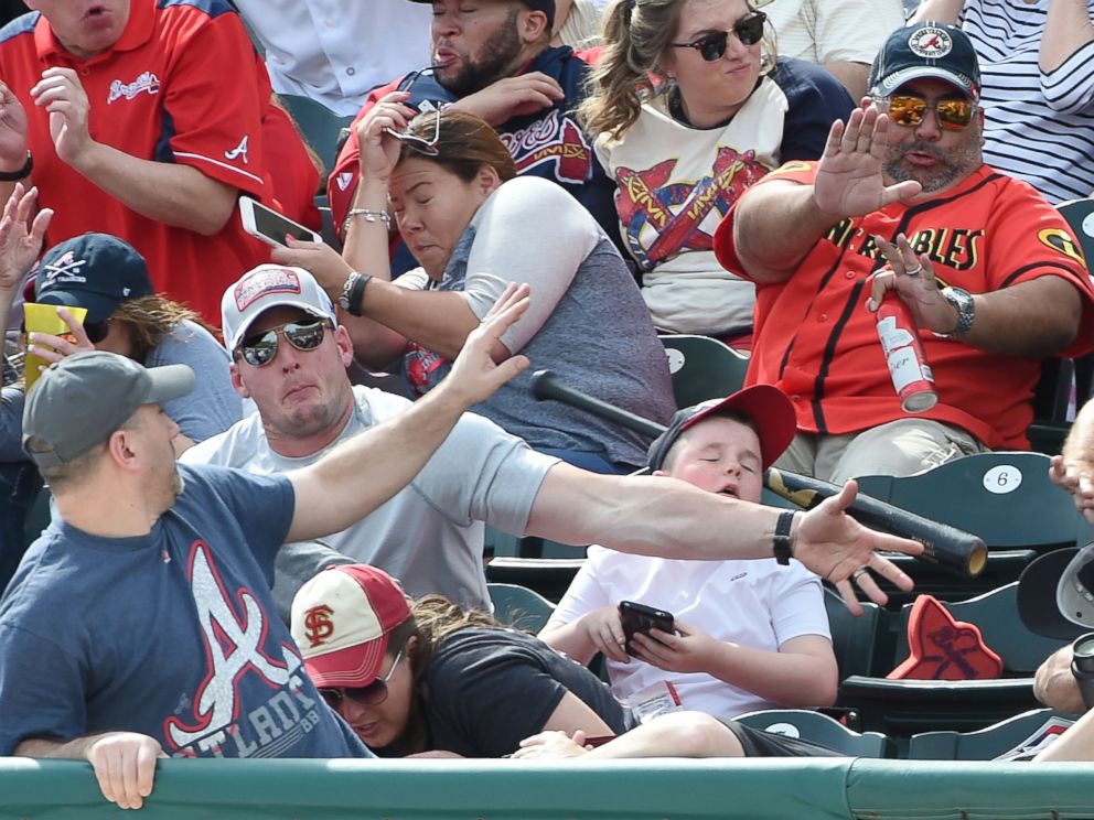 PHOTO: A fan knocks down a bat thrown into the stands by the Pirates Danny Ortiz during a spring training game against the Braves on March 5, 2016, at Champion Stadium in Lake Buena Vista, Fla.