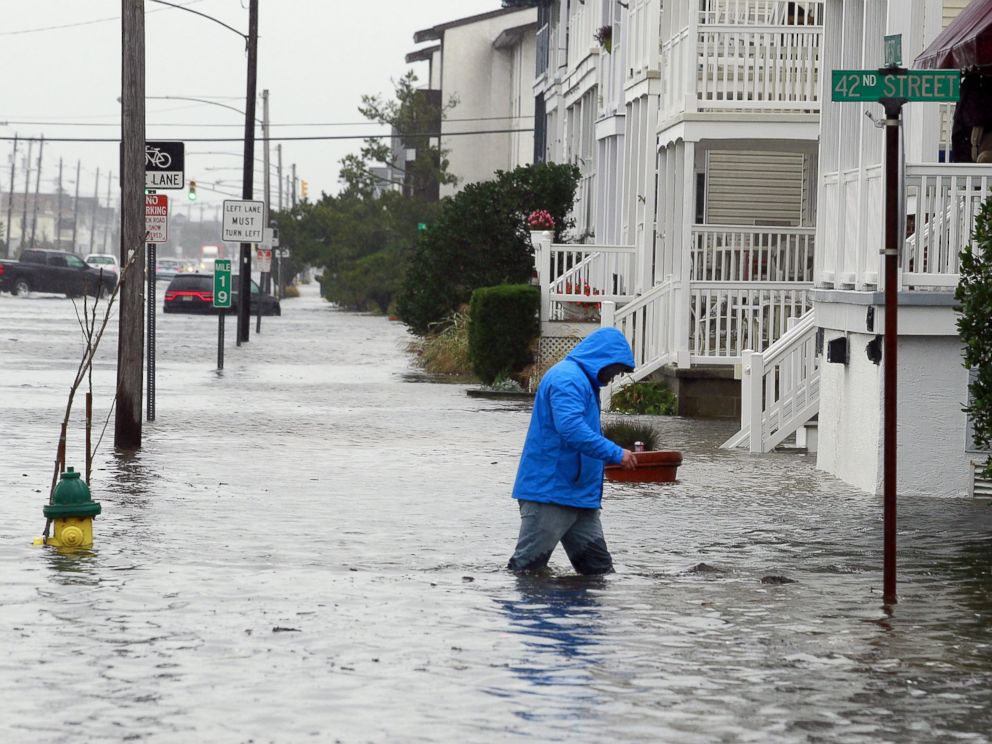 PHOTO: A man walks through knee-deep water along a flooded West Avenue as a nor-easter comes on shore in Ocean City, N.J., Oct. 2, 2015.