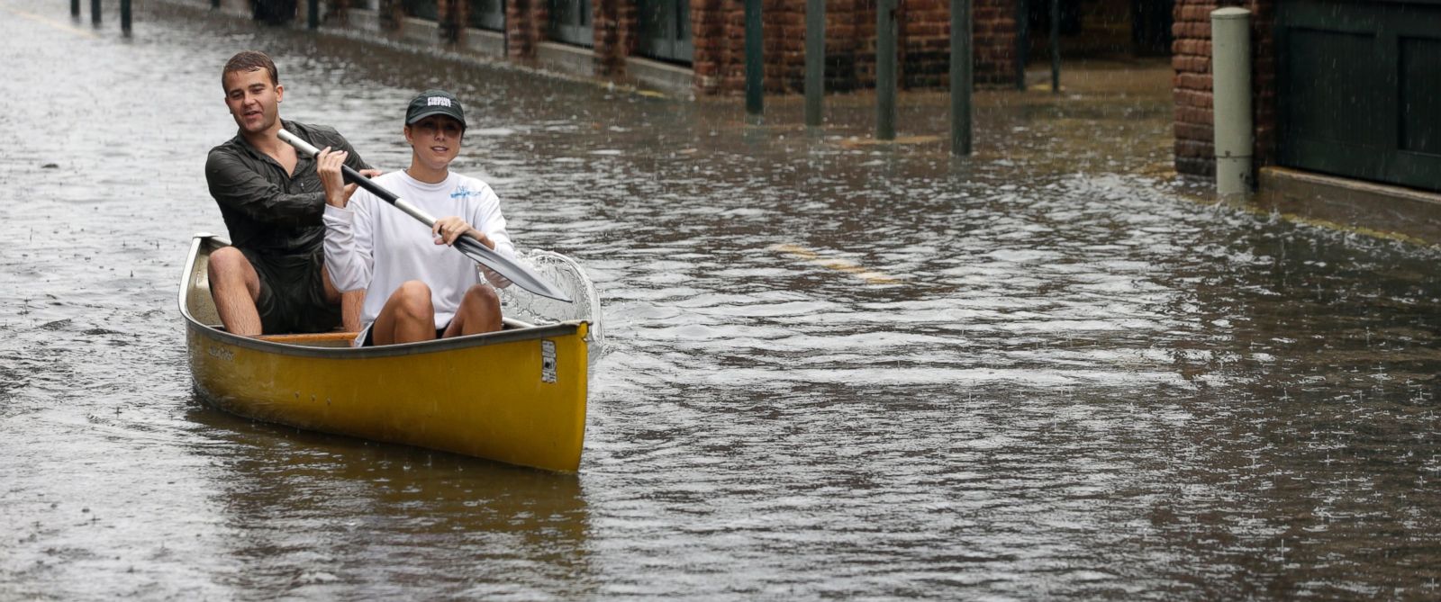PHOTO: Dillon Christ, front, and Kyle Barnell paddle their canoe down a flooded street in Charleston, S.C., Saturday, Oct. 3, 2015.