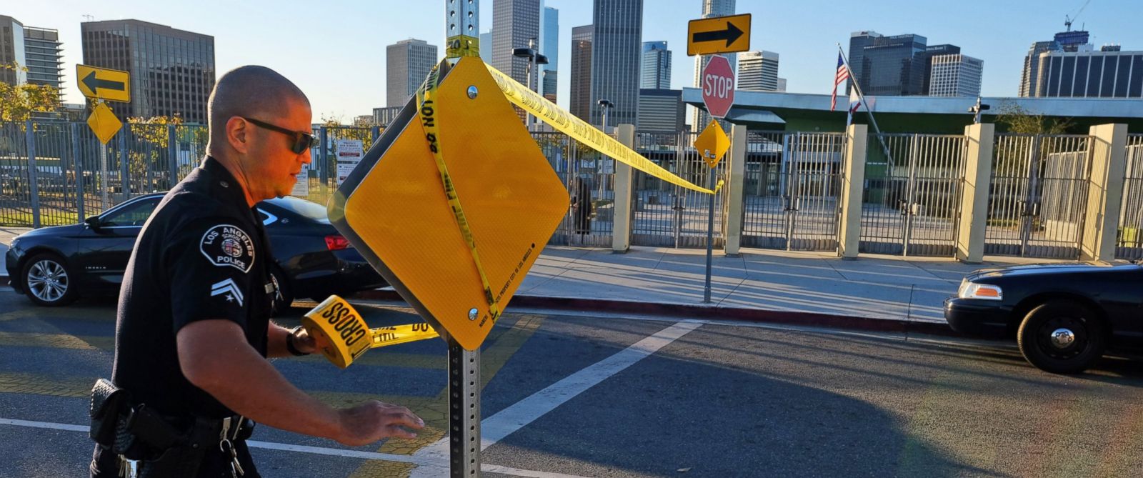 PHOTO: A police officer puts up yellow tape to close the school outside of Edward Roybal High School in Los Angeles, Dec. 15, 2015.