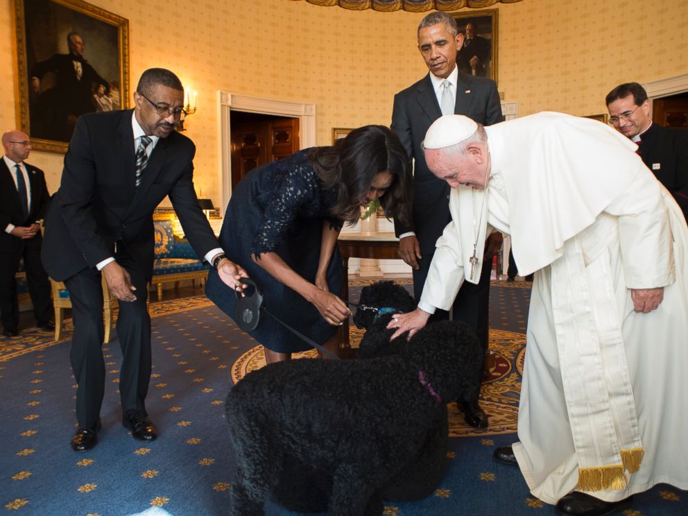 PHOTO: In this photo provided by LOsservatore Romano, Pope Francis and first lady Michelle Obama pet the Obamas dogs as President Barack Obama looks at the White House in Washington, Sept. 23, 2015.